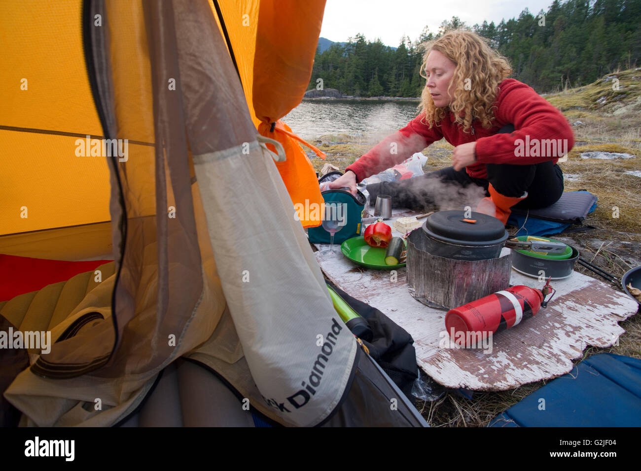 Frau im Zelt, camping am Kunechin Point, Sechelt Inlet. Gibsons, Sunshine Coast, British Columbia, Kanada Stockfoto