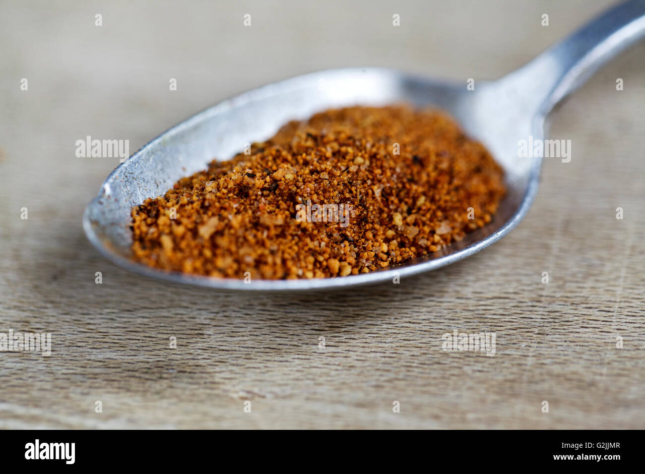 Getrocknete Chili Paprikaflocken auf Metalllöffel präsentiert Stockfoto