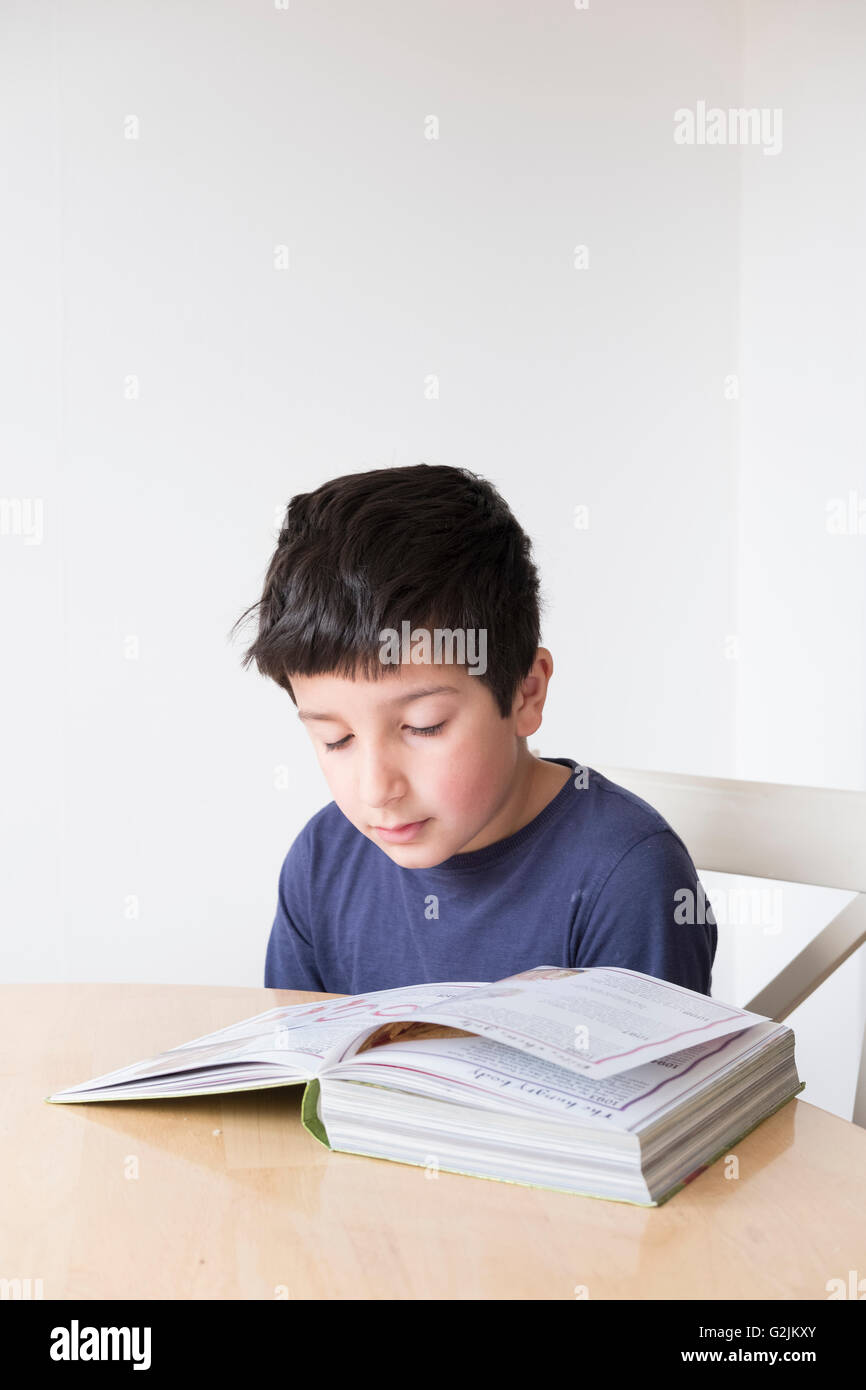 Junge, 8 Jahre alt, ein Buch zu lesen Stockfoto