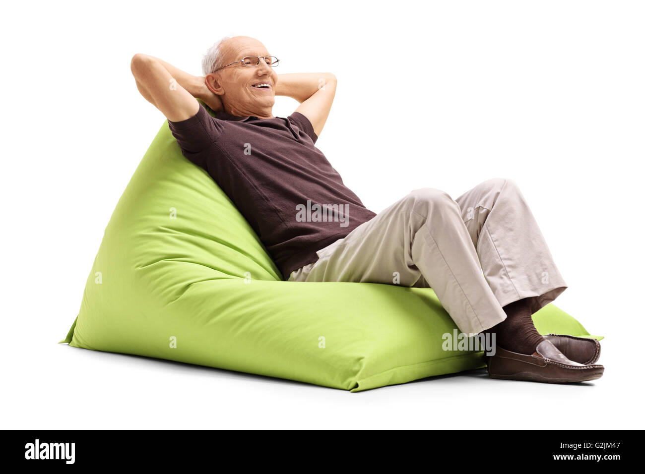 Entspannte senior Herren sitzen auf eine angenehm grüne Sitzsack isoliert auf weißem Hintergrund Stockfoto