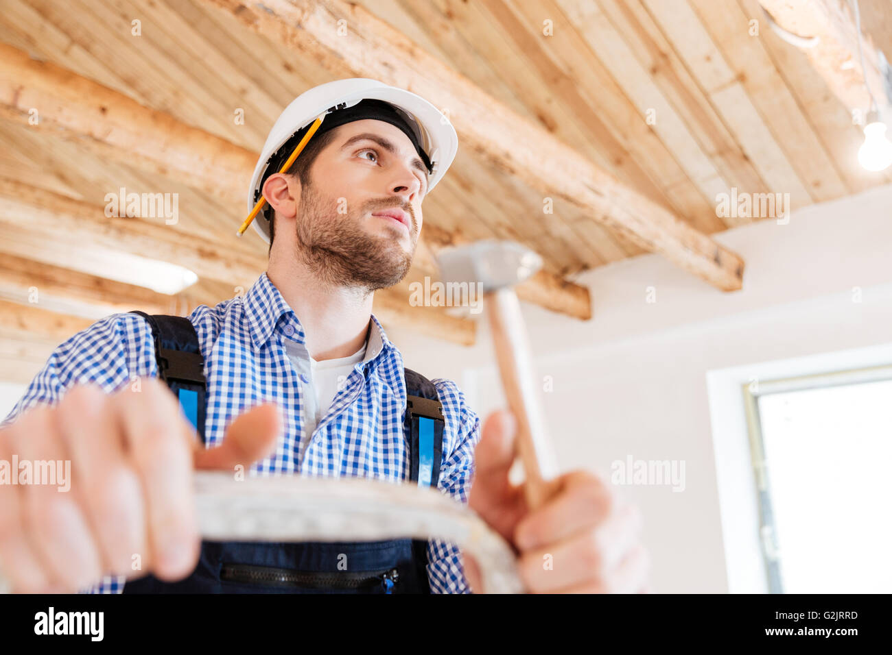 Close-up Portrait von einer Concentratedbuilder mit einem Hammer in der Hand auf der Arbeitsfläche Stockfoto