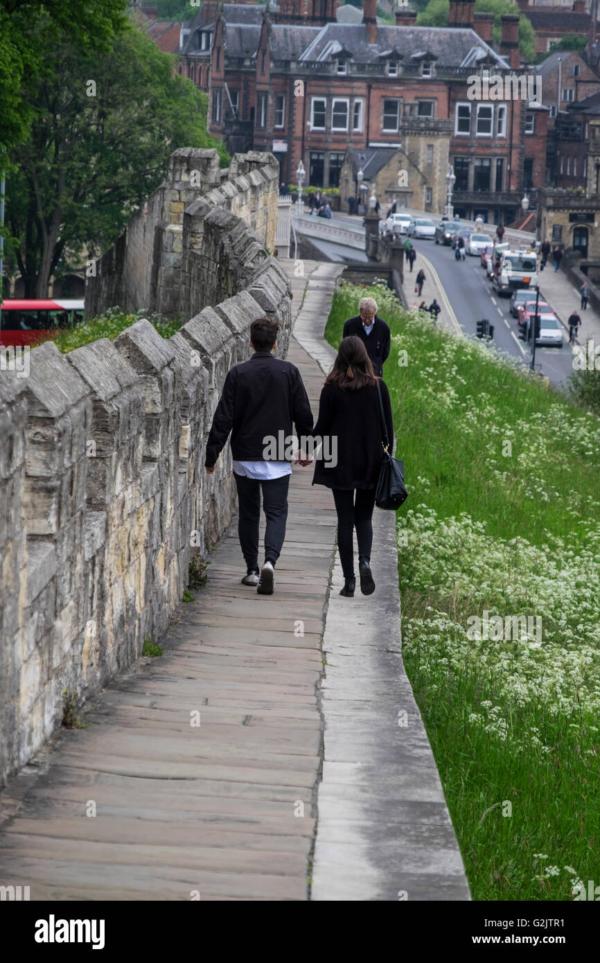 Junges Paar gehen hand in hand entlang der alten Stadtmauer von York Stockfoto