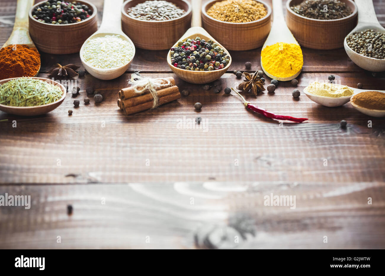 Schöne bunte Gewürze in Holzlöffel auf einem alten Holz- braun Tabelle. freier Platz für Ihren Text Stockfoto