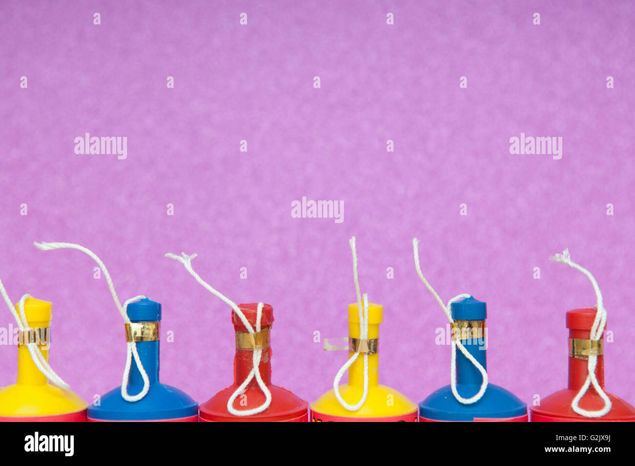 Bunte Party Poppers in einer Reihe auf einem hellen Hintergrund angeordnet Stockfoto