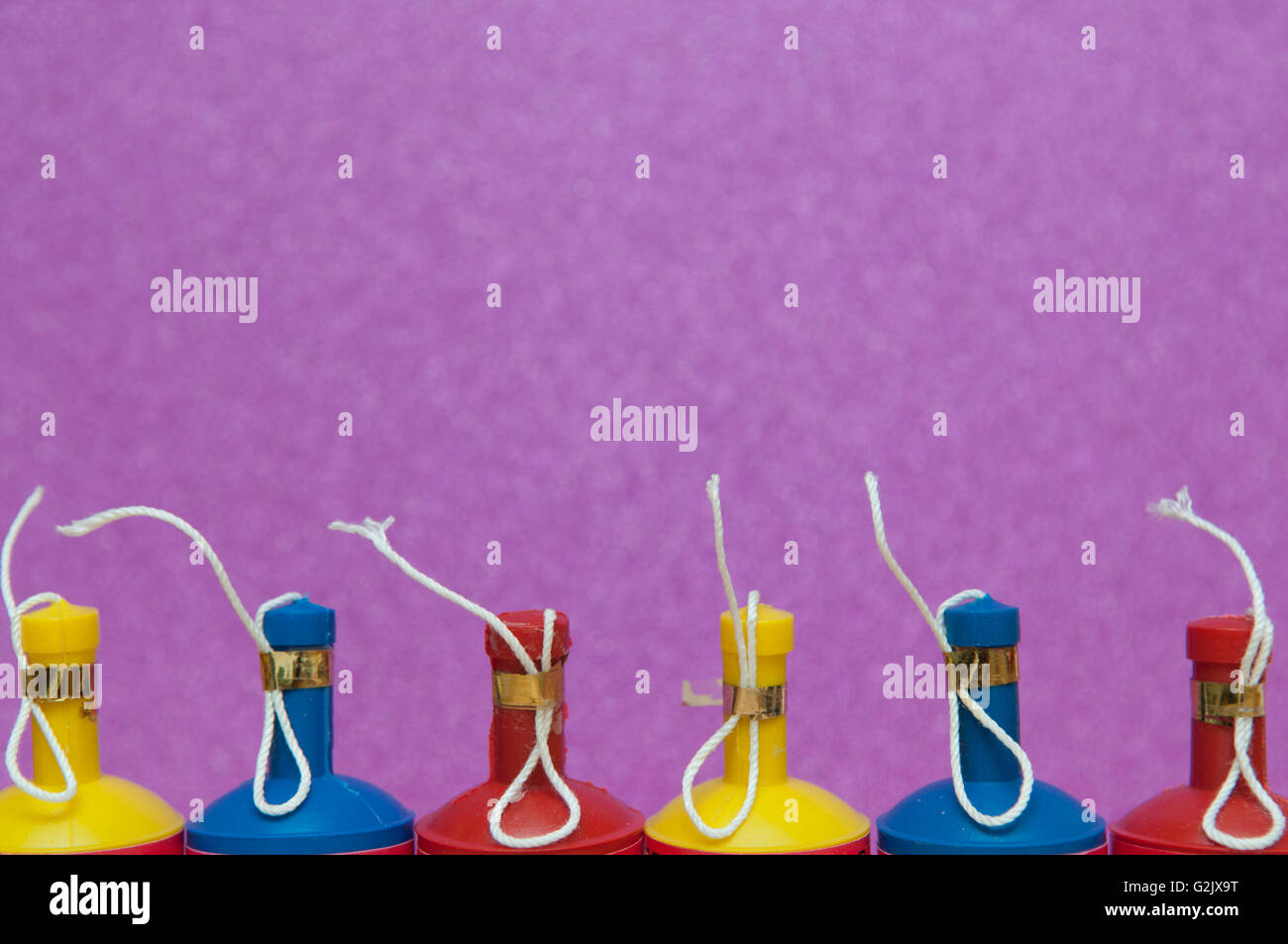 Bunte Party Poppers in einer Reihe auf einem hellen Hintergrund angeordnet Stockfoto
