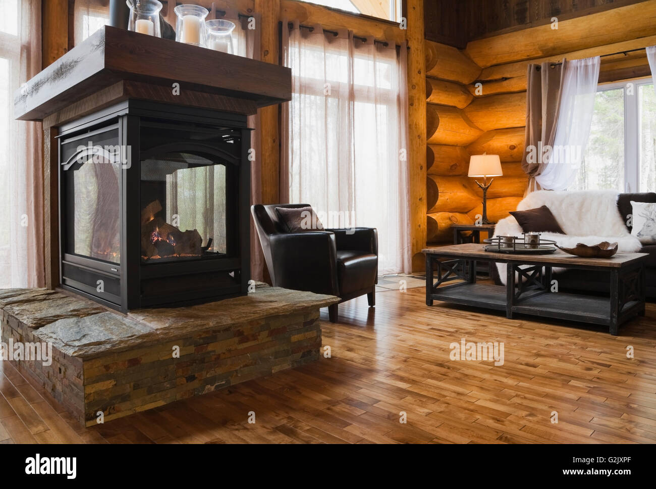 Gas-Kamin auf eine erhabene Steinplatte Basis braun Stuhl Couchtisch aus  Holz Ledersofa im Wohnzimmer in einem luxuriösen Ferienhaus Stockfotografie  - Alamy