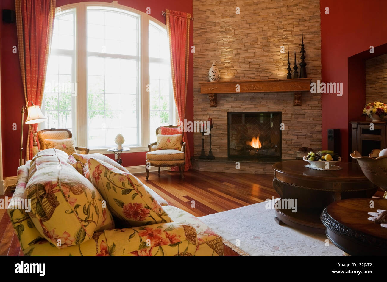 Blumige gepolstertes Sofa Wohnzimmerstühle beleuchtet Gas-Kamin im eleganten Landhaus Stil nach Hause Quebec Kanada dieses Bild Stockfoto