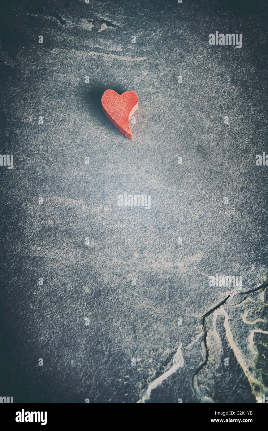 Vintage getönten Holzes rotes Herz auf Stein Grunge Hintergrund, geringe Schärfentiefe, Platz für Text. Stockfoto