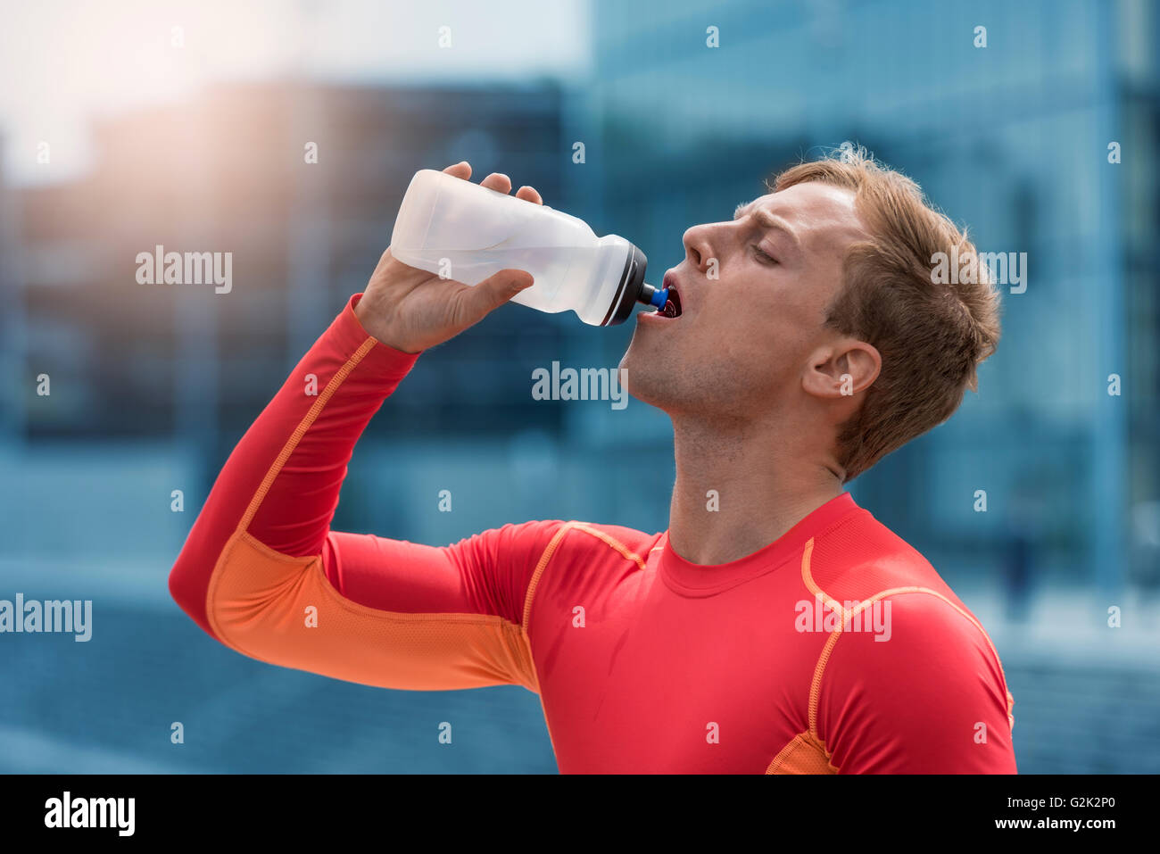 Athletische Sportler trinken Energy-Drink. Stadt Mann Fließwasser Stockfoto