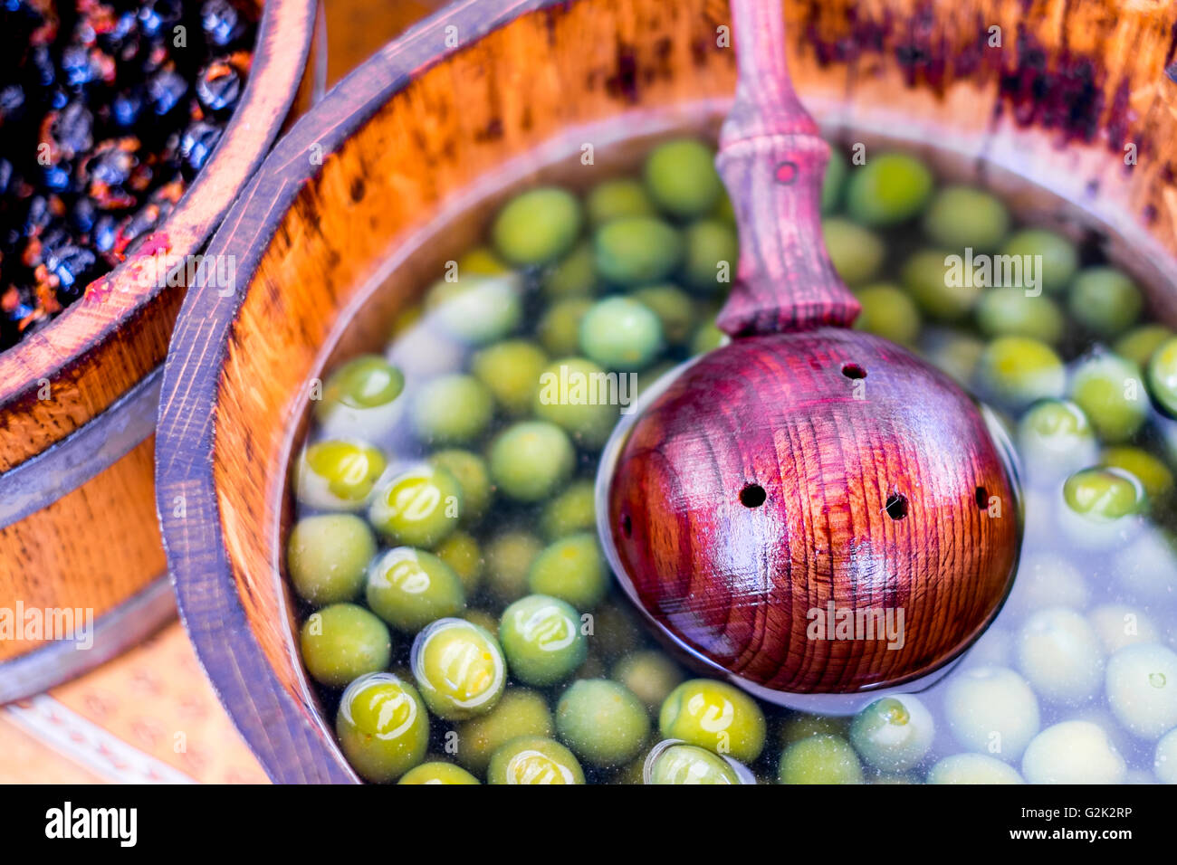 Olivenöl und mediterranen Speisen Händler verkauft Oliven in Holzkisten Fässer Eimer auf dem Marktplatz in Cambridge Stockfoto
