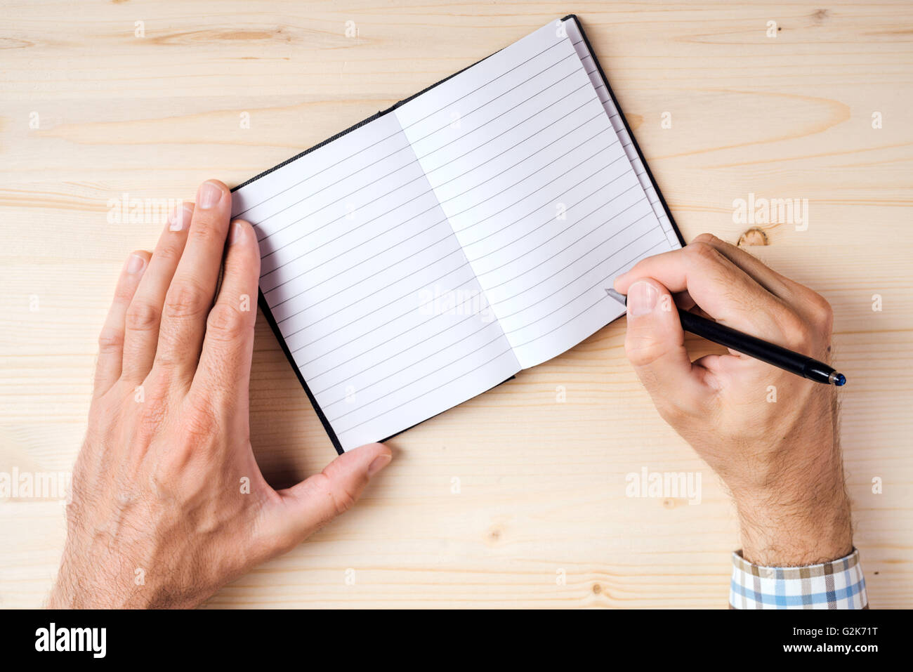 Menschen, die Schreiben von Notizen im Notizbuch, Draufsicht von Hand mit Bleistift auf Tisch Stockfoto