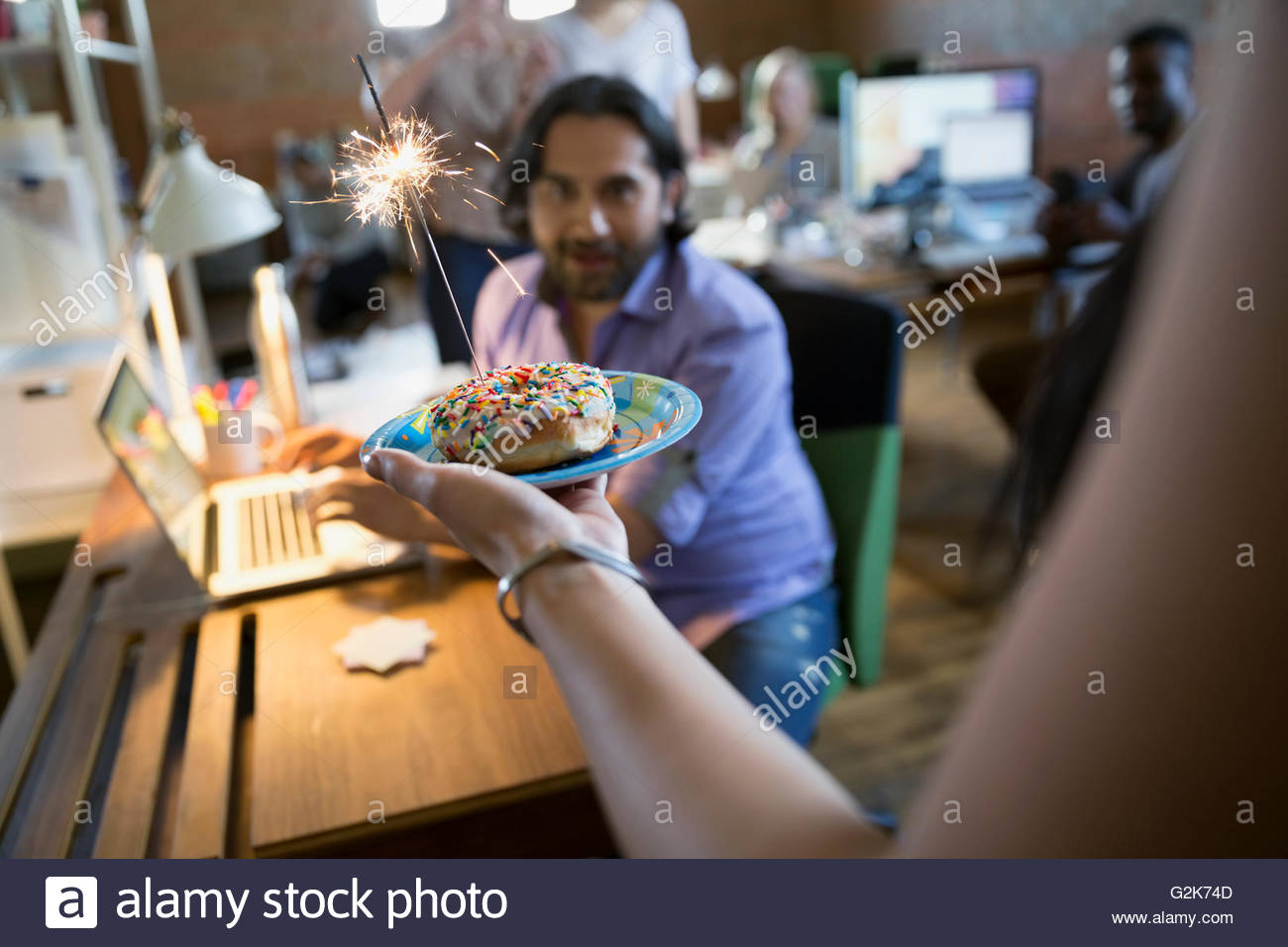 Mitarbeiter, kreative Geschäftsmann Geburtstag Donut mit Wunderkerze Stockfoto