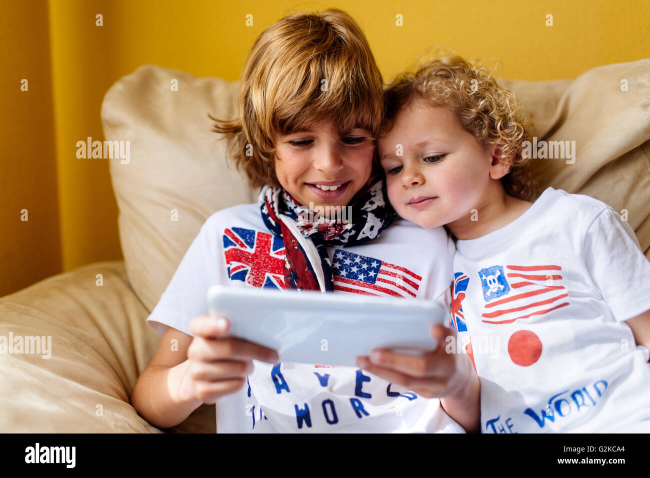 Porträt von zwei jungen auf Couch mit digital-Tablette Stockfoto