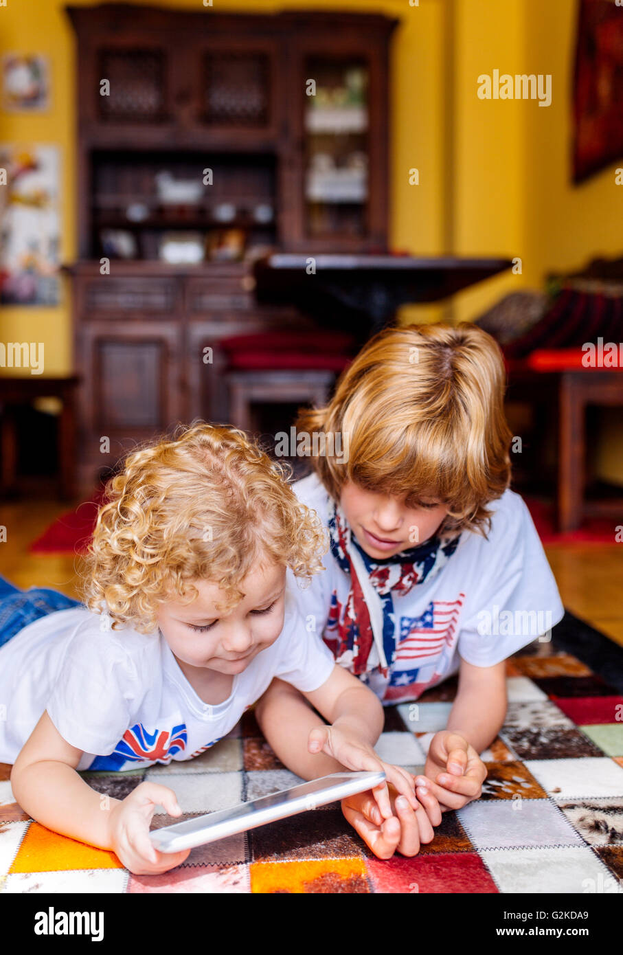 Zwei Jungs auf dem Boden zu Hause zu spielen, mit digital-Tablette Stockfoto