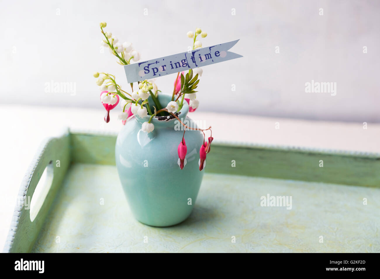 Blumen-Vase von Maiglöckchen und Lyra-Blumen auf Tablett Stockfoto