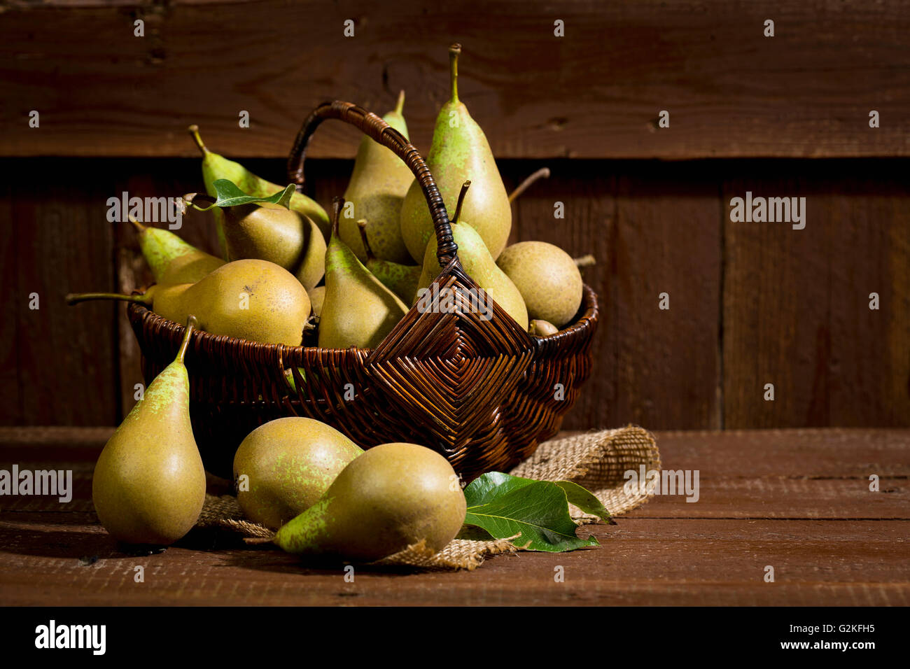 Wickerbasket Bio Birnen auf Holz Stockfoto