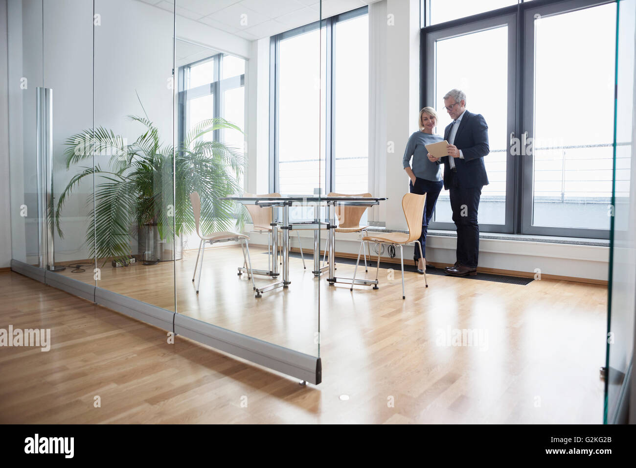 Geschäftsmann und Frau im Büro Blick auf digital-Tablette Stockfoto