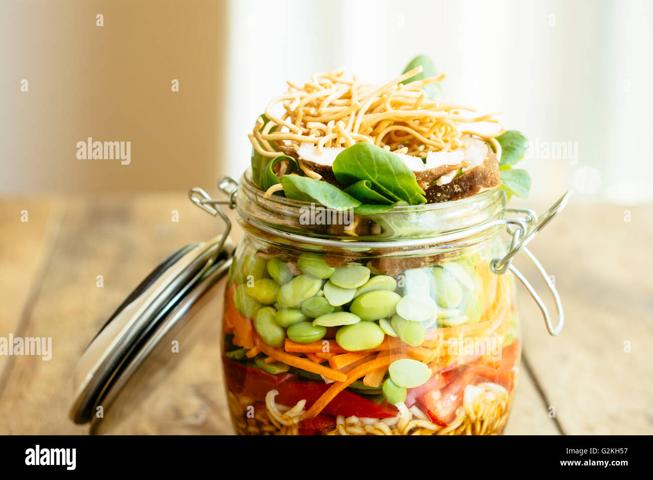 Asiatischer Salat in ein Gefäß mit Ramen-Nudeln, rote Paprika, Schnee Erbsenschoten, Karotten, Edamame, Shiitake-Pilze, Salat, gebratene Chow Mien Nudeln und dressing Stockfoto