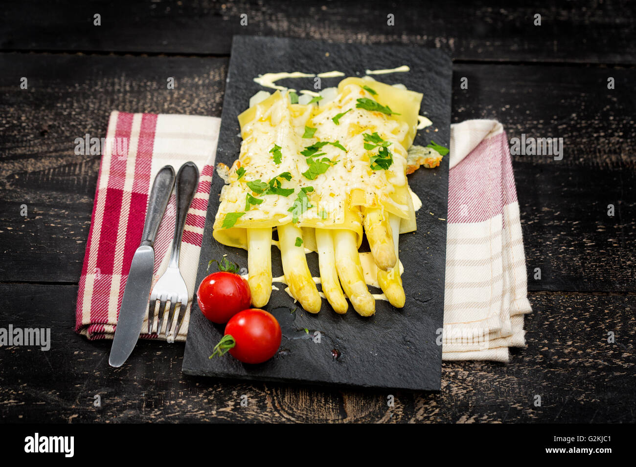 Cannelloni gefüllt mit weißem Spargel, überbacken mit Käse auf Schiefer Teller Stockfoto