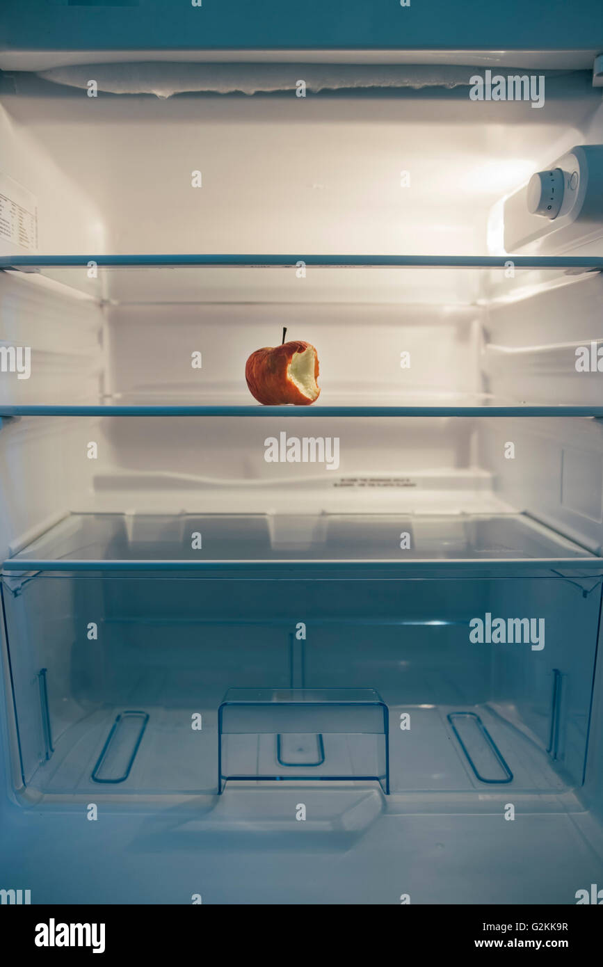 Fast leerer Kühlschrank mit einem gebratene angebissene Apfel Stockfoto