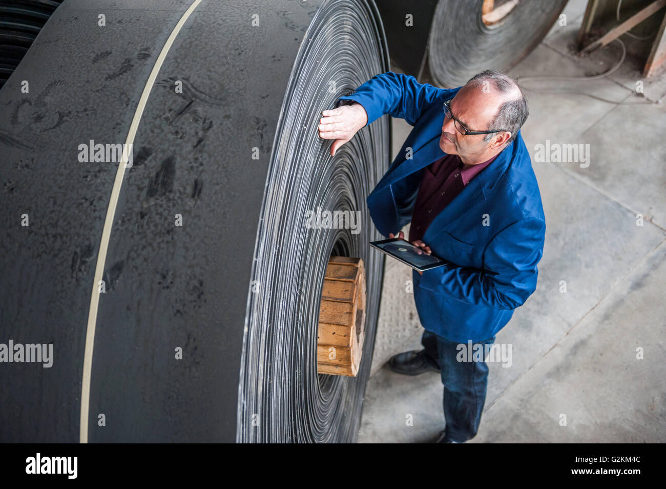 Manager mit digital-Tablette in Fabrik Halle Examiming Rollen Gummi Stockfoto