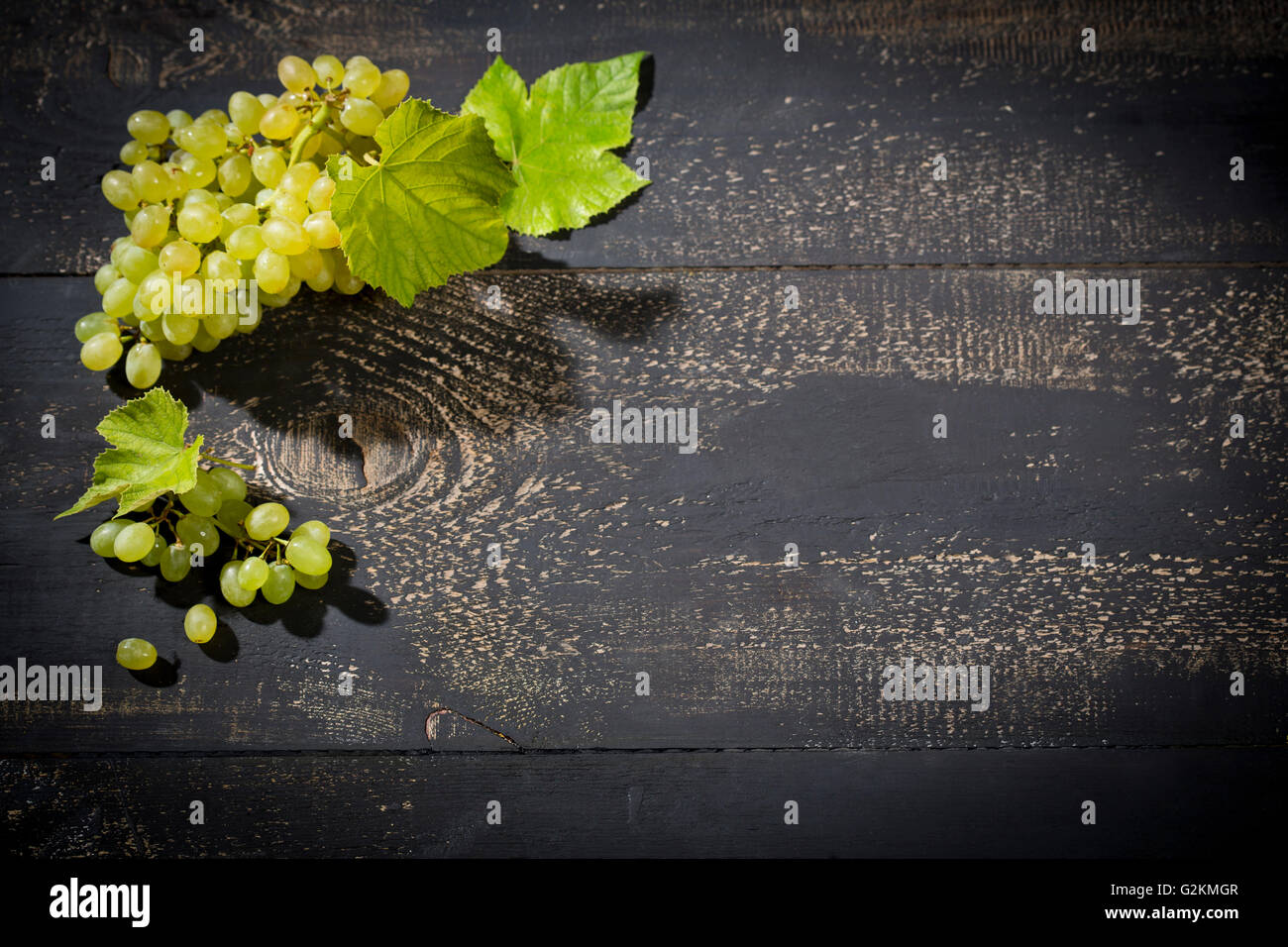 Grüne Trauben auf dunklem Holz Stockfoto