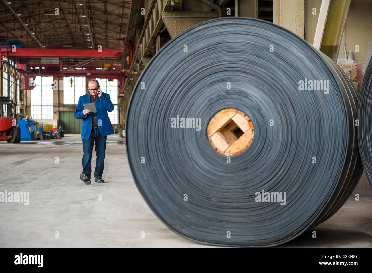 Manager mit digital-Tablette in Fabrikhalle mit Rollen aus Kautschuk Stockfoto