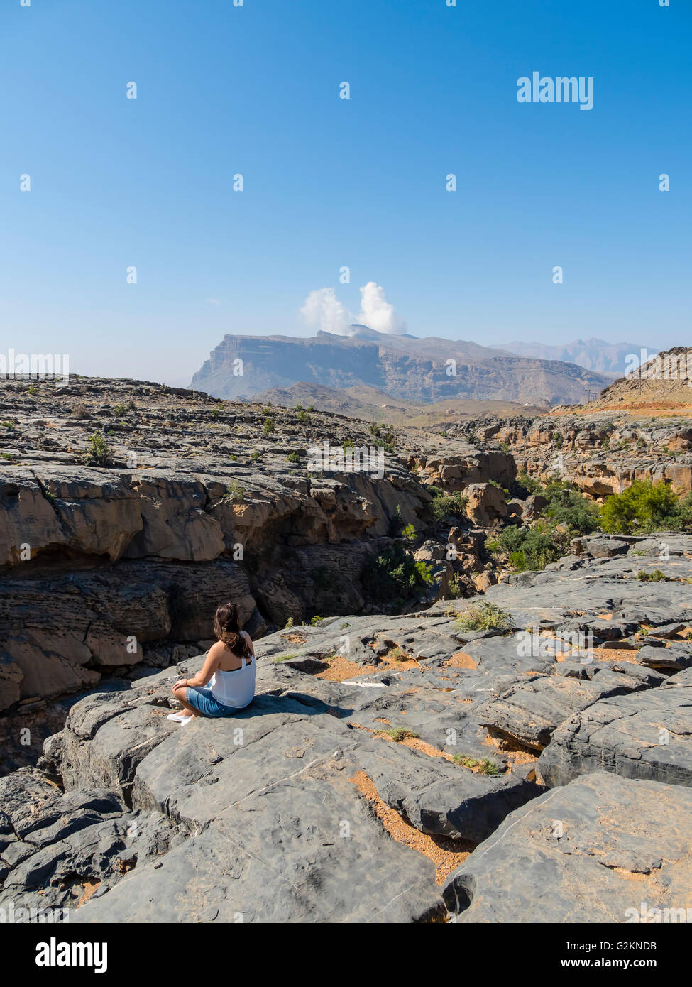 Oman, Jebel Shams, Frau sitzt am Aussichtspunkt Stockfoto