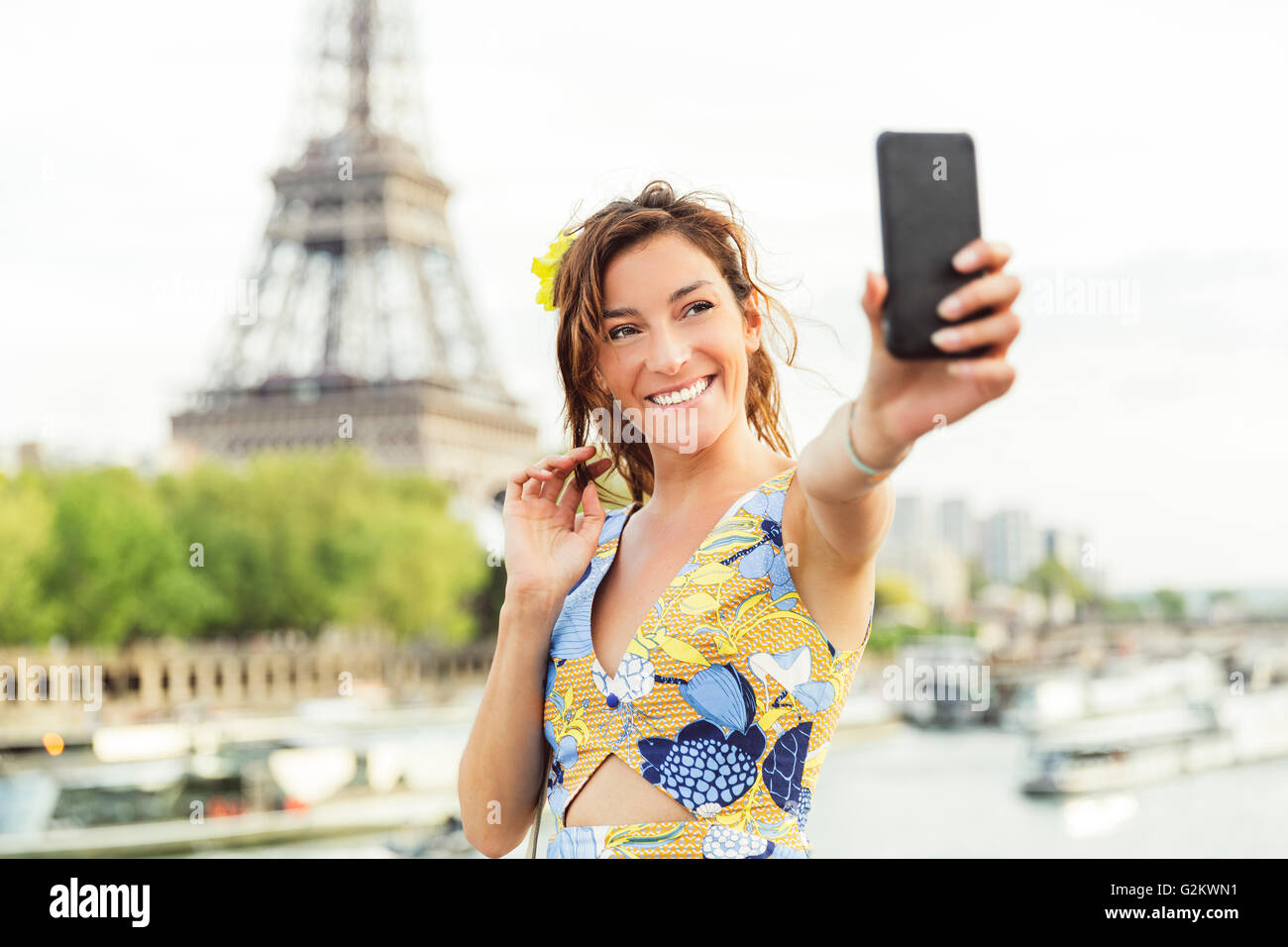 Paris, Frau tut ein Selbstporträt mit Eiffelturm auf Hintergrund Stockfoto