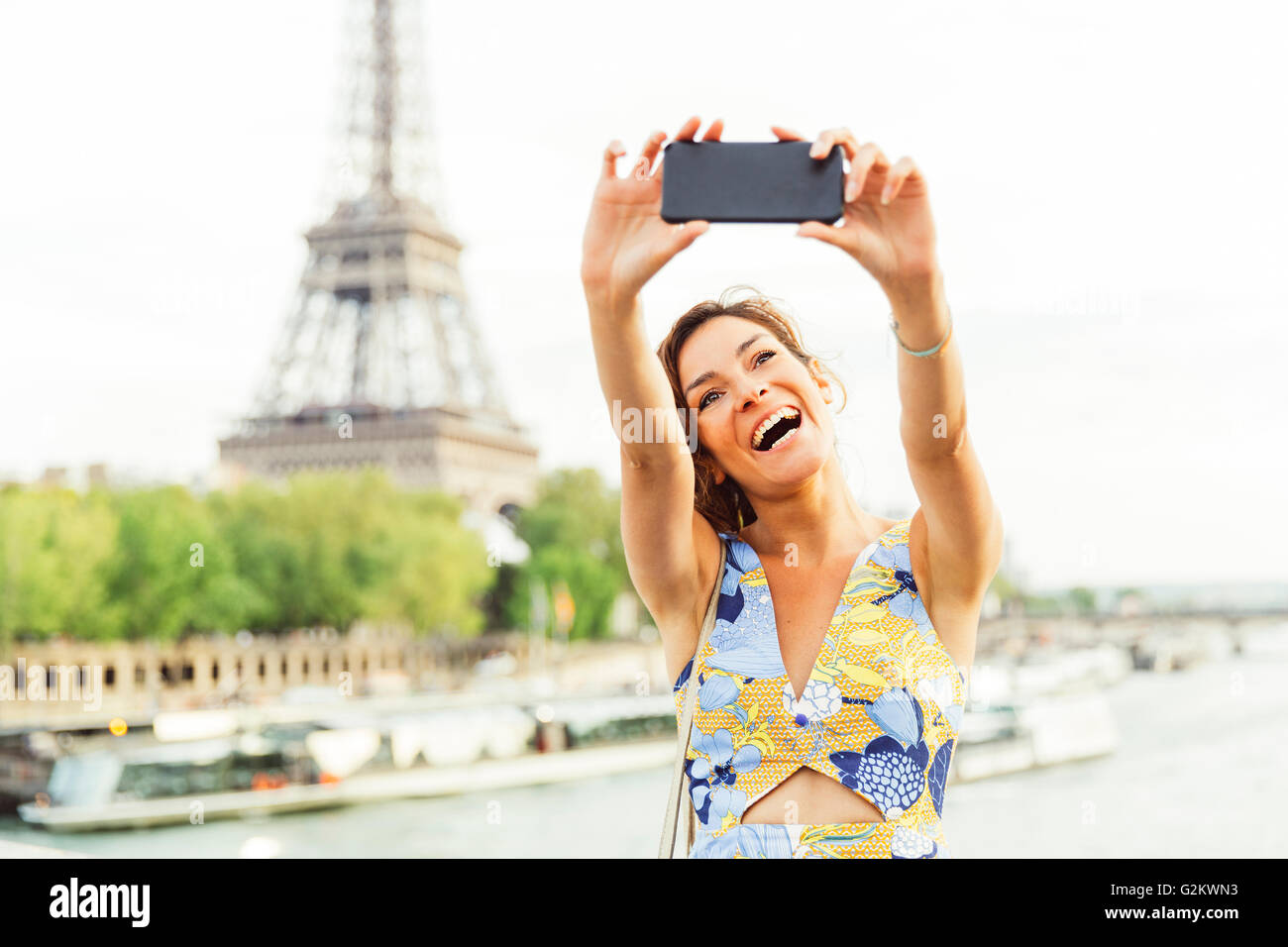 Paris, Frau tut ein Selbstporträt mit Eiffelturm auf Hintergrund Stockfoto
