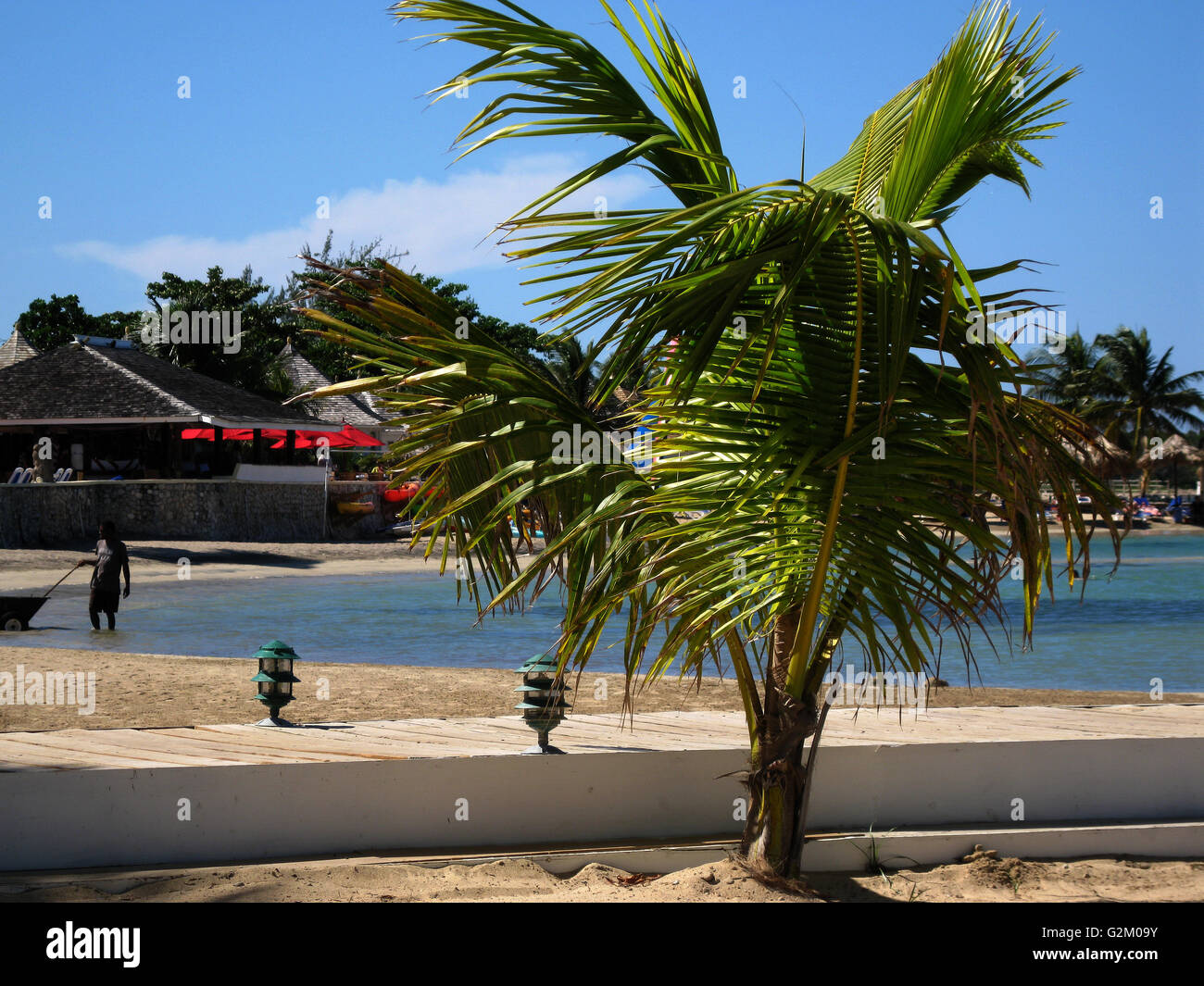 Schöne Sonne beleuchtet warmen karibischen Strand, goldenen Sand und dramatische Himmel, Decameron Hotel, Runaway Bay, mit Kokospalmen Stockfoto