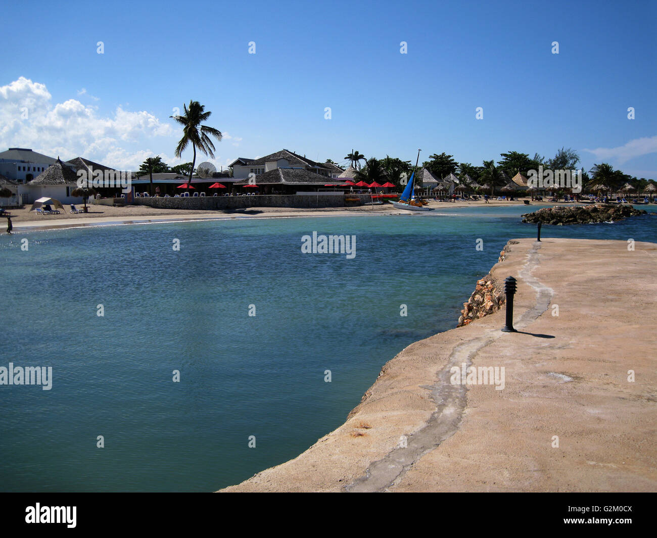 Schöne Sonne beleuchtet warmen karibischen Strand, goldenen Sand und dramatische Himmel, Decameron Hotel, Runaway Bay, mit Kokospalmen Stockfoto