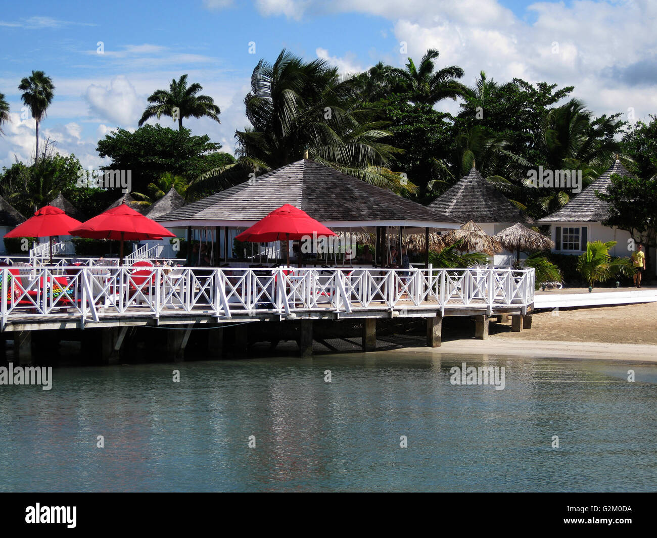 Schöne Sonne beleuchtet warmen karibischen Strand, goldenen Sand und dramatische Himmel, Decameron Hotel, Runaway Bay, mit Kokospalmen Stockfoto
