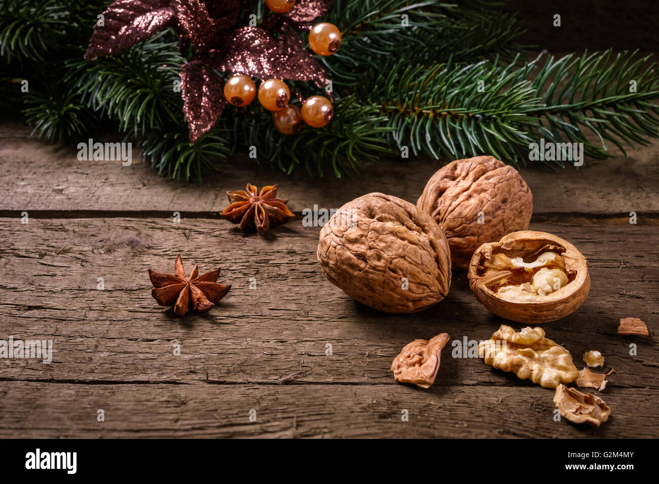 Anis, Tanne Zweig, Cranberries und Walnüssen auf Holzbohlen. Sie können es für Weihnachten Hintergrund, Karte oder Gutschein verwenden. Stockfoto