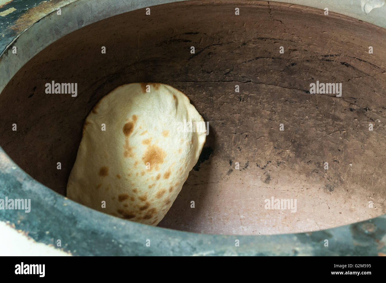 Traditionelle Naan-Brot dabei, in einem Lehmofen backen. Stockfoto