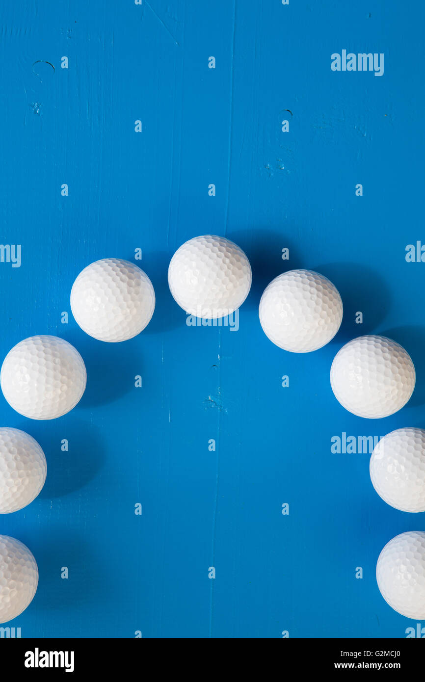 Weiße Golfbälle auf dem blauen Holztisch - flach legen Fotografie Stockfoto