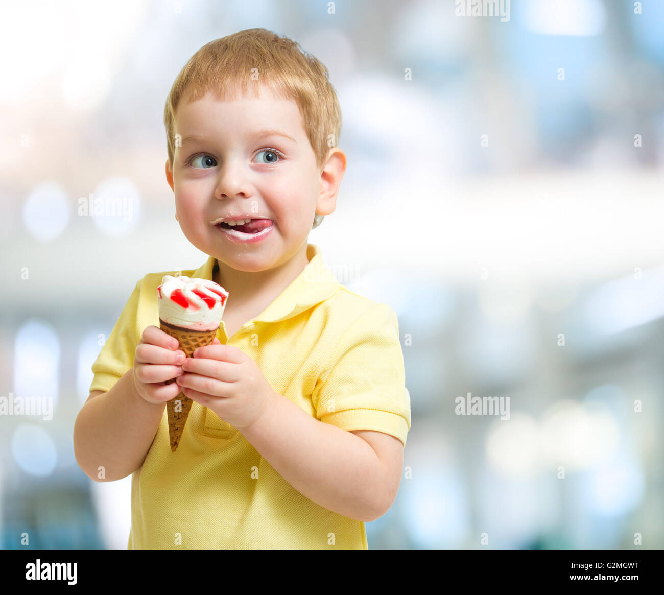 Glückliches Kind essen Eis auf unscharfen Hintergrund Stockfoto