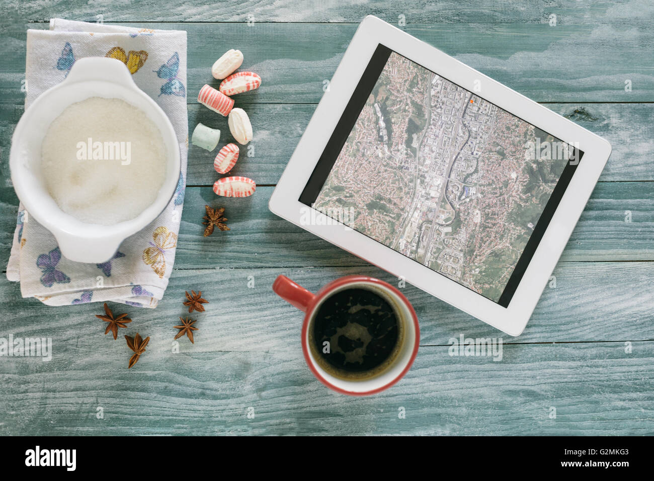 Kaffee und Tablet auf bunten groben Holztisch Stockfoto
