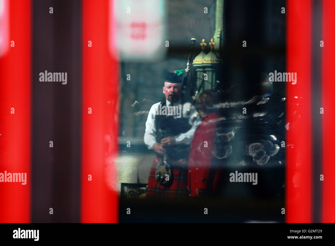 Ein Blick durch einen roten Londoner Bus eine Straße Entertainer Dudelsack auf Westminster Bridge Stockfoto