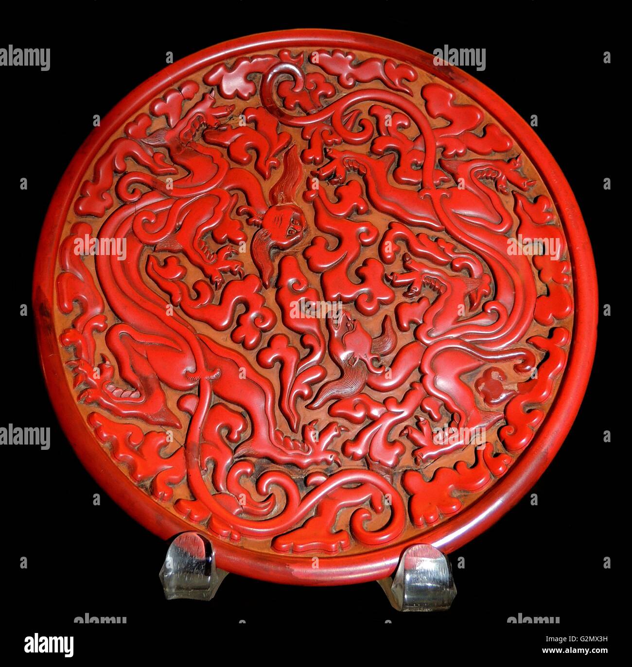 Runde rote lack Teller mit zwei chi Drachen und einem guri Stil Blättern geschnitzt. Ming Dynastie, Ende 14. Jahrhundert AD Stockfoto
