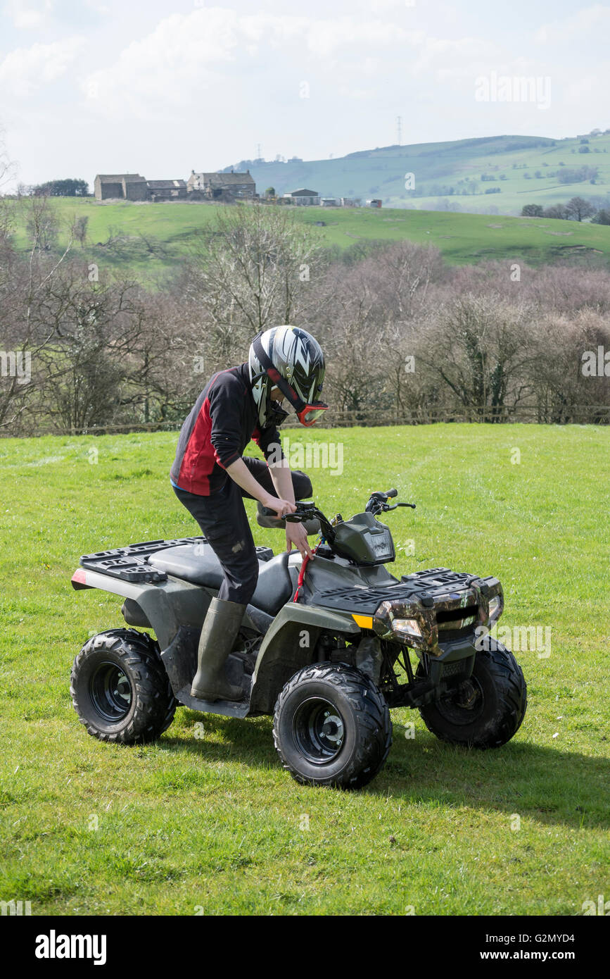 Junge auf einem Quad-Bike in einem Feld in der englischen Landschaft. Stockfoto