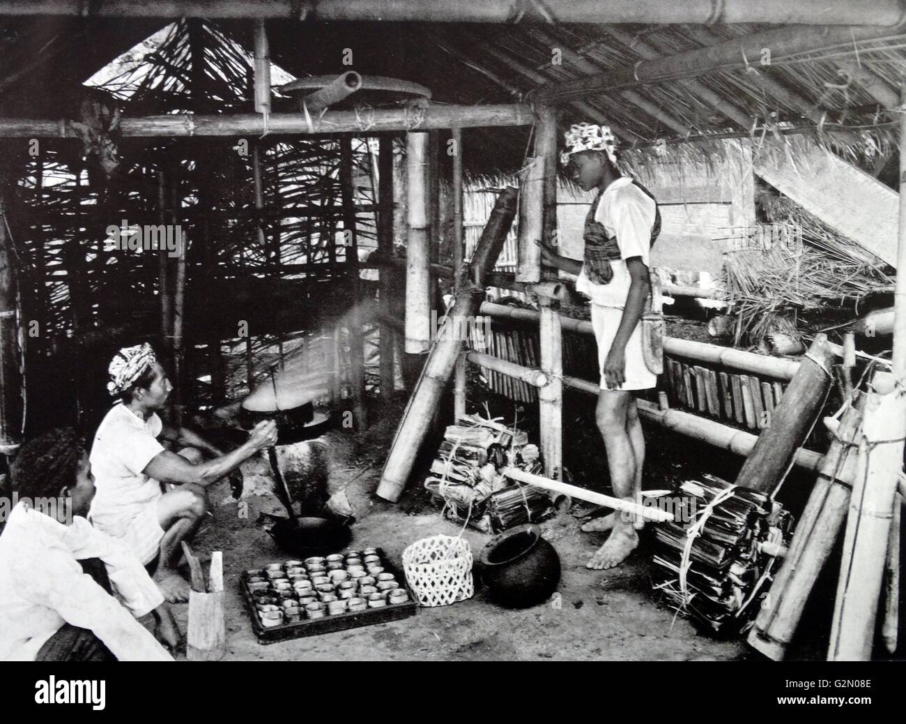 Foto zeigt männlichen Figuren in einem indonesischen Home kochen Zucker Spikes. Niederländisch-ostindien, wie moderne Indonesien bekannt. Vom c 1935. Stockfoto