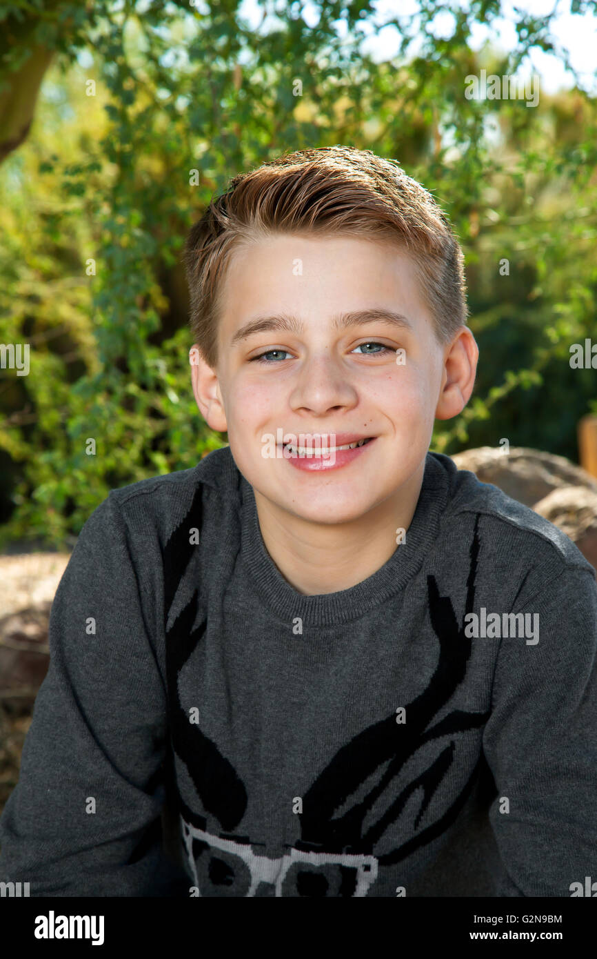 Porträt von einer Blondine, Tween jungen lächelnd in die Kamera im Freien. Stockfoto