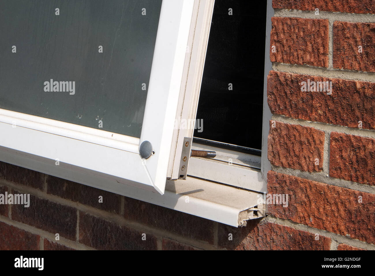 Große grob gebohrt Schraube durch ein uPVC doppelt verglaste Fenster zur Verbesserung der Sicherheit. Mai 2016 Stockfoto