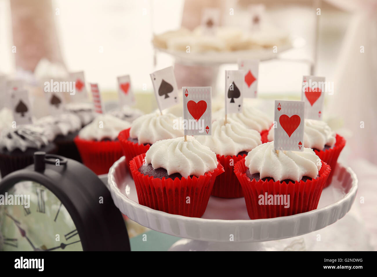 Red Velvet Cupcakes mit Spielkarten Topper, Alice im Wunderland-Tea-Party, Muskelaufbau Stockfoto