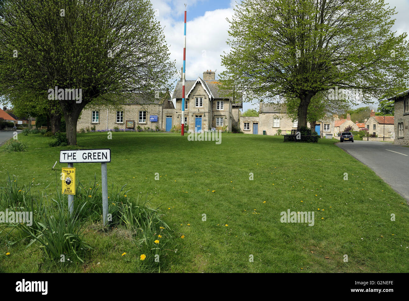 Die grüne, Slingsby, North Yorkshire, England, Vereinigtes Königreich, zeigt der Maibaum und der Schule im Hintergrund. Stockfoto