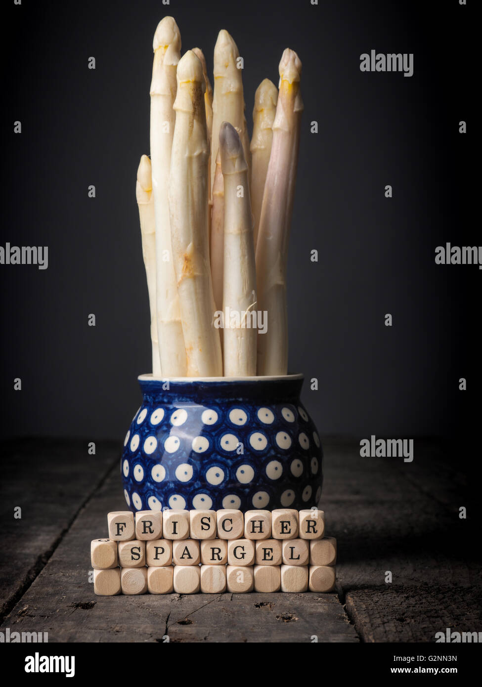 Frischer weißer Spargel in einer rustikalen Schüssel, hölzernen Würfel mit den deutschen Worten von frischem Spargel Stockfoto