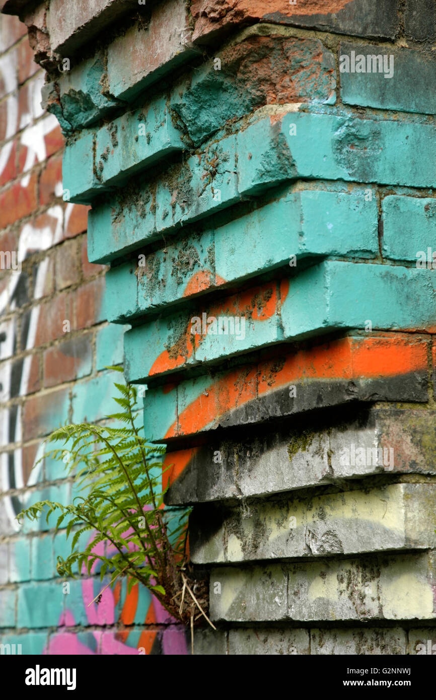 Graffiti auf Ziegel corbelling auf verlassenen alten Industriegebäude. Stockfoto