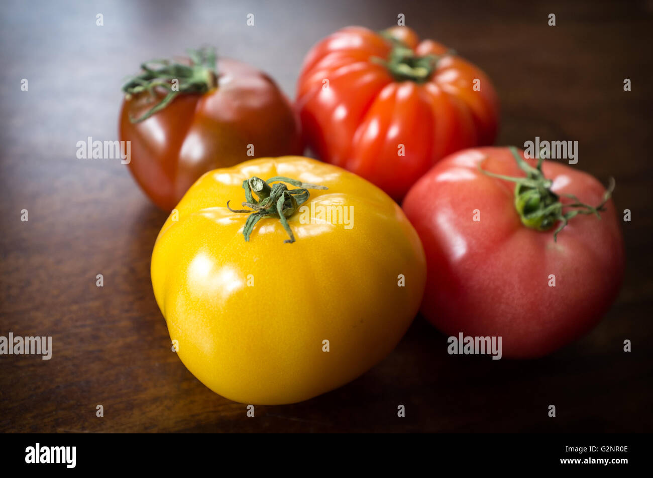 Farbenfrohe saftige Erbstück oder Erbe Tomaten auf Holztisch Stockfoto