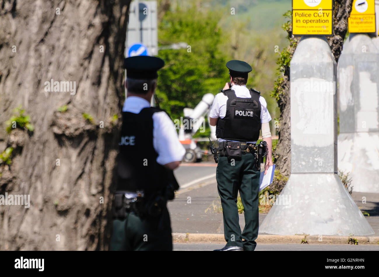 Belfast 26.05.2012 - PSNI Offiziere anwesend auf der Kalkstein-Straße, wo ein Verdacht Gerät entdeckt wurde.  Im Hintergrund ist ein Northropp Grumman Andros Cutlass Bombe Beseitigung Roboter Stockfoto